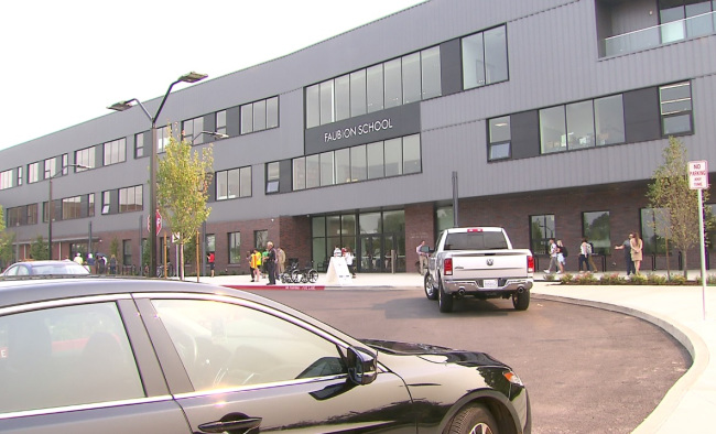 An outdoor shot of the Faubion School facility, with two cars in the photo.