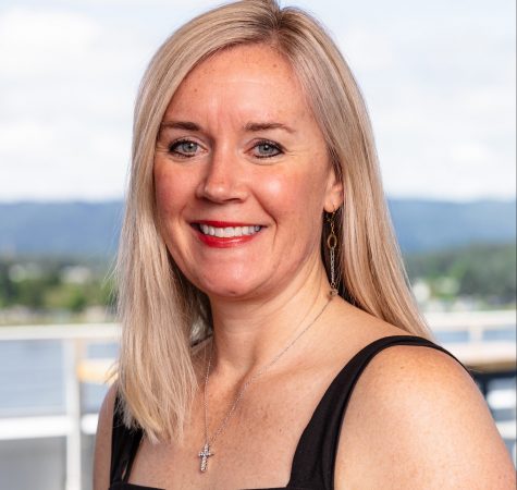 A woman with straight blond hair smiles for the camera