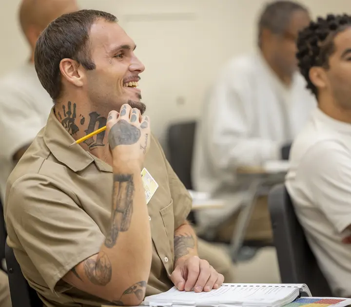 Four people in a scientific research lab, wearing lab attire and gloves and conducting resarch.