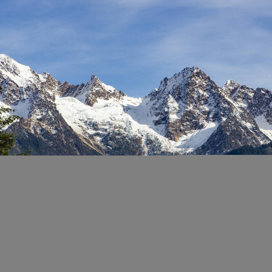 Snow covered mountains against a blue sunny sky