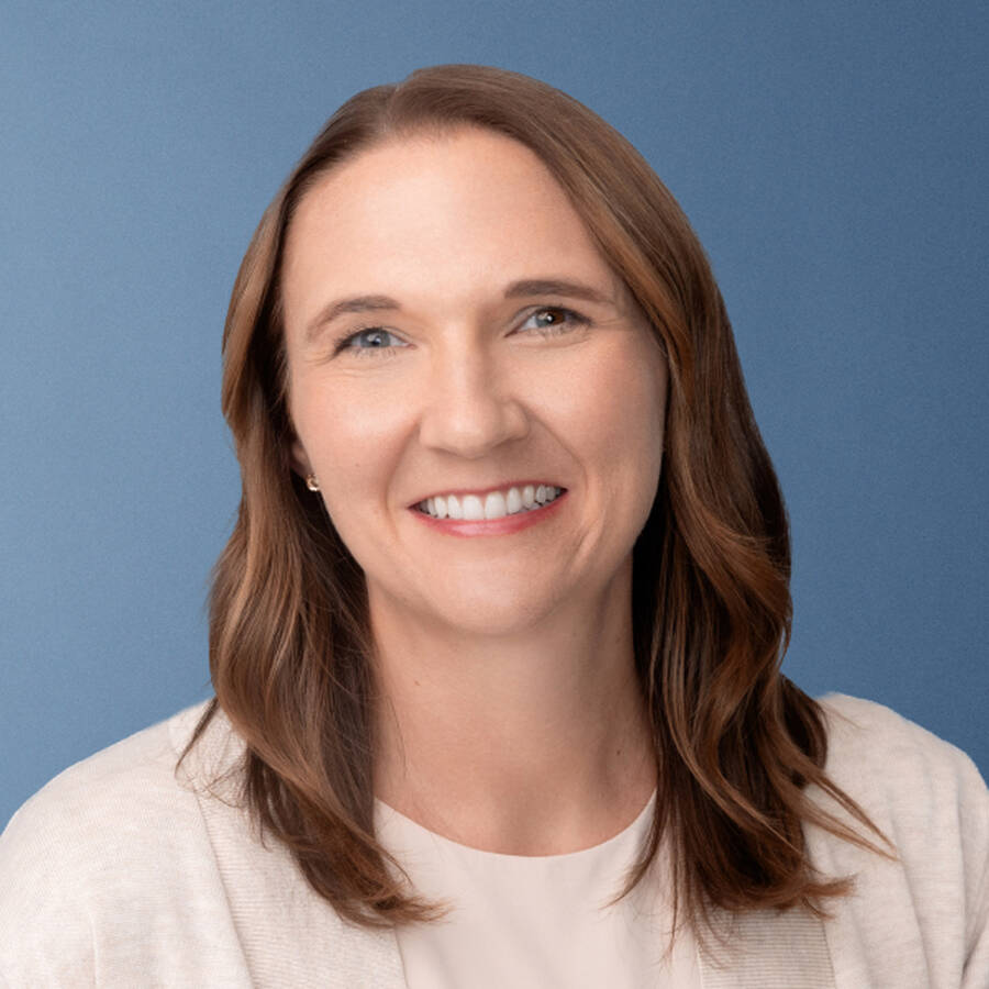 Portrait of person smiling against a plain blue background